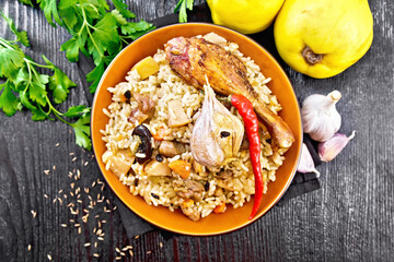 Pilaf with duck and quince in plate on board top