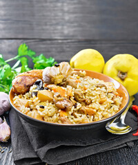 Pilaf with duck and quince in plate on towel