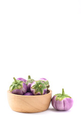 Fresh organic Thai purple eggplant in wooden bowl on white background, Food ingredient