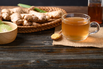 Ginger tea with lime and honey on wooden background, Healthy herbal drink