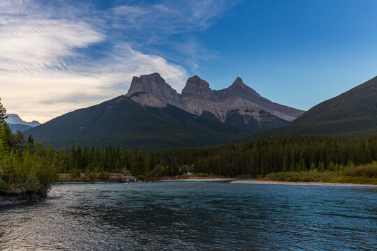 A beautiful reflection of the Three sisters in Policeman Creek, Hope, Faith and Charity in Canmore, Canadian Rockies.