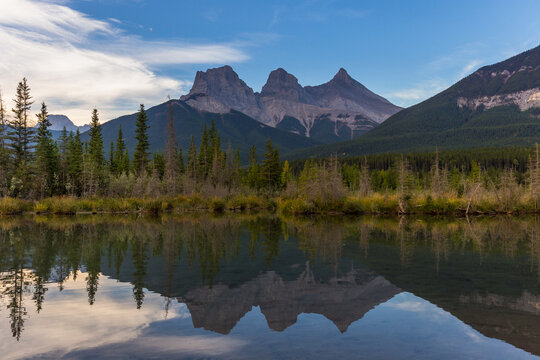 A beautiful reflection of the Three sisters in Policeman Creek, Hope, Faith and Charity in Canmore, Canadian Rockies.