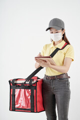 Female courier with big bag taking notes on tablet computer or checking address of customer