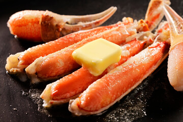 バターを乗せたずわいがにの鉄板焼き　Grilled snow crab with butter on an iron plate © Nishihama