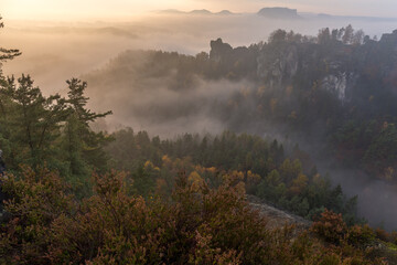Sunrise in autumn foggy valley near Bastei