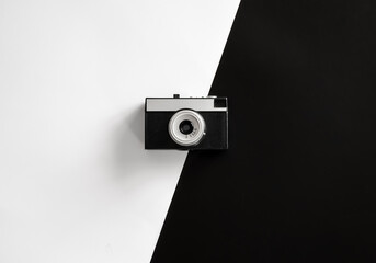 Vintage retro camera on black and white background, flat lay.