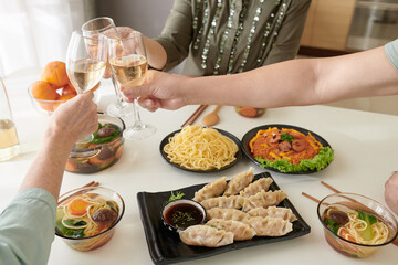 Smiling senior woman telling toast at dinner party with female friends