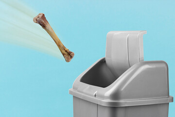 Throw the bone in the trash, gray bucket on a blue background, the concept of lunch, breakfast,...