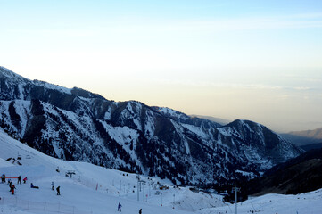 Active lifestyle and sports: rest in a ski resort. Skiing, snowboarding. Nice alpine view. Bright sunset
