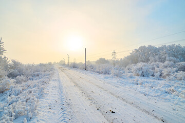 The road goes into the misty distance on a sunny winter day.