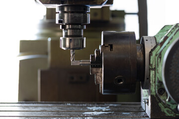 Worker hand working on the milling machine to change metal drill bit. Tool for drilling metal workpiece. Milling machine. Steel manufacturing industry. Metalwork industry. Industrial drilling machine.
