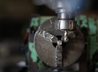 Fototapeta na wymiar Worker hand working on the milling machine to change metal drill bit. Tool for drilling metal workpiece. Milling machine. Steel manufacturing industry. Metalwork industry. Industrial drilling machine.