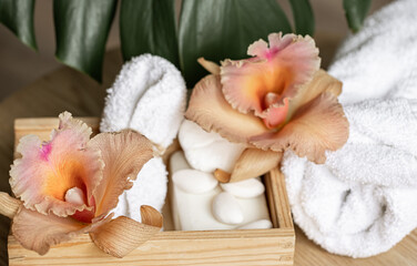 Fototapeta na wymiar Spa composition with body care products in a wooden box and Thai orchid flowers.