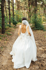 Fototapeta premium Beautiful wedding bride running in the garden