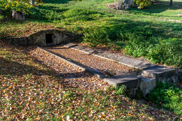 Ancien lavoir recouvert de feuilles en automne en Auvergne