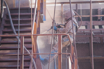 Sandblasting the paintwork of metal structures before painting - obrazy, fototapety, plakaty