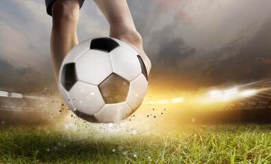 Soccer ball with football player kick off under the spot ray light effects on green field in 3D illustrations, of free space for texts and branding.