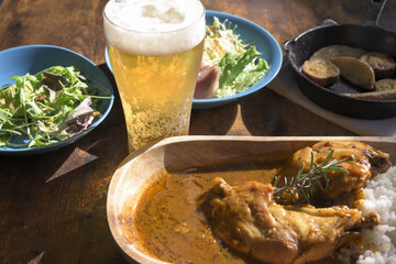 食卓の上のチキンカレーと生ビール