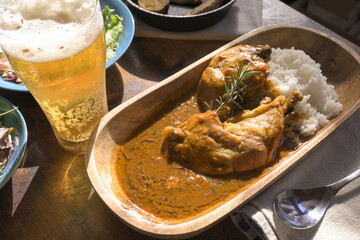 食卓の上のチキンカレーと生ビール