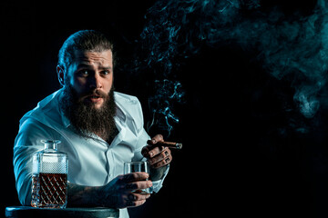 Hipster bearded man smoke a cigar drinks whiskey, blows smoke, dressed in white shirt. Studio shot