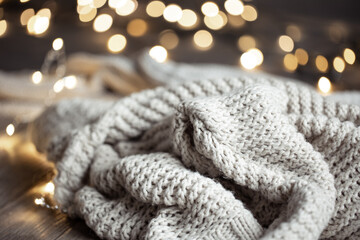 Knitted sweater close-up on blurred background with bokeh.