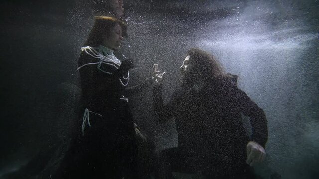 love of queen and knight, medieval historical underwater shot, man and woman are drinking wine