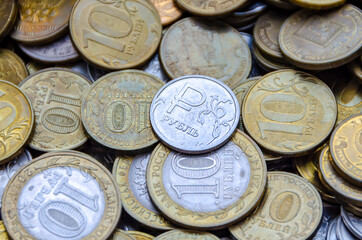 A coin with the sign of the Russian ruble lying on other iron coins.