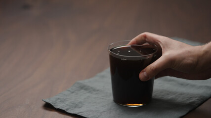 man hand take cola in tumbler glass from linen cloth with copy space