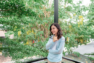 Young woman stands on the balcony with notepad in hand