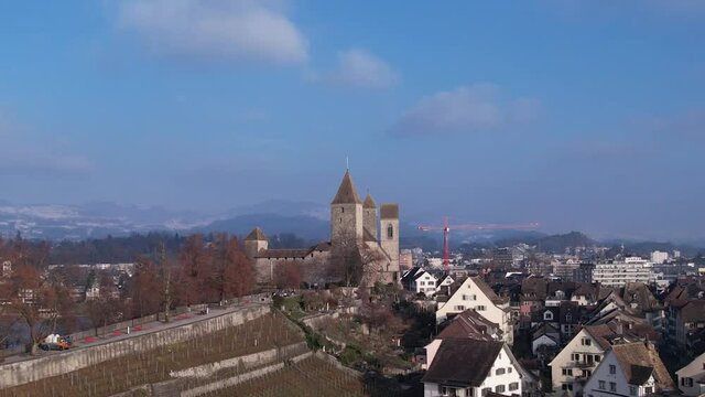 Majestic medieval castle and roman old town in Swiss city Rapperswil, aerial orbit
