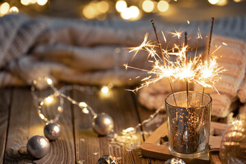 Cozy Christmas background with glowing sparklers and decor details.