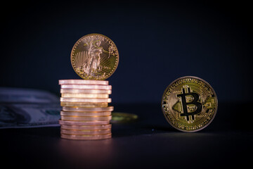  bitcoin coin stands next to a stack of other gold coins