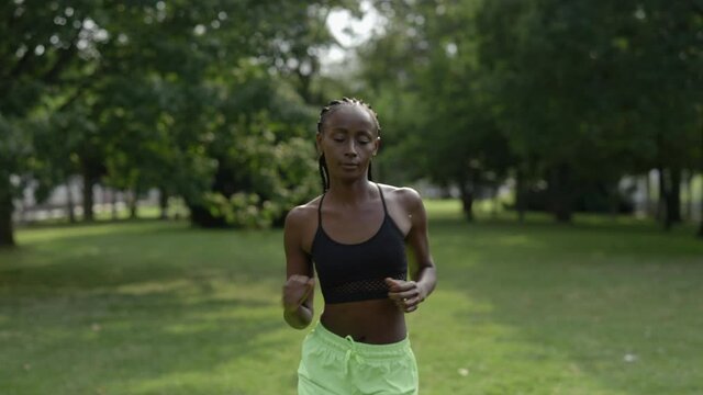 Active african american woman running at city park