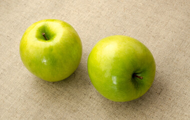 two green apple lying on a table