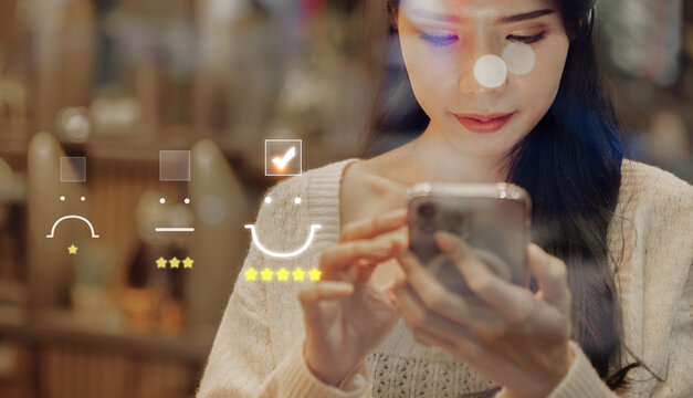 Business Woman pressing face emoticon on virtual touch screen at smartphone .Customer service evaluation concept.