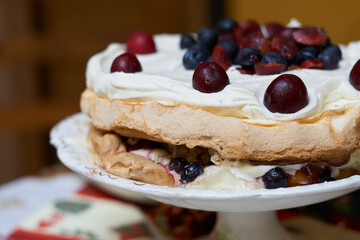 close-up of cake with meringue, cream and red berries or Pavlova