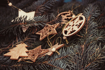 Christmas toys, wooden, on the branches of a Christmas tree, photo indoors with light