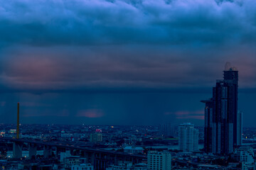 Fototapeta premium The high angle background of the city view with the secret light of the evening, blurring of night lights, showing the distribution of condominiums, dense homes in the capital community
