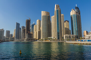 Fototapeta na wymiar Modern skyscrapers and water pier of Dubai Marina, United Arab Emirates