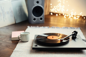 Obraz na płótnie Canvas Turntable playing vinyl LP record at home party. Have fun, enjoying life, leisure, listening to music, hobby, lockdown, winter cozy lifestyle concept