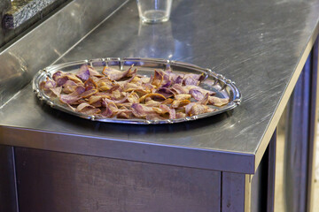 tray of purple potato chips on a stainless steel table
