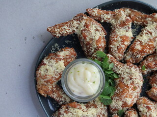 Tasty grilled chicken wings with mayo sauce close-up on a plate. horizontal view from above.