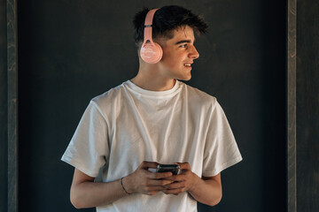 young man with mobile phone or smartphone and headphones on the street