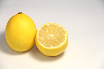 Whole and a half lemons. On a white background.