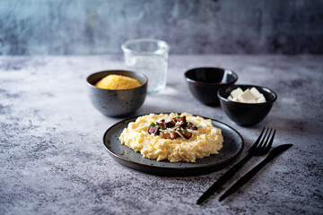 Corn porridge with fried bacon, parsley and Feta cheese in a bowl