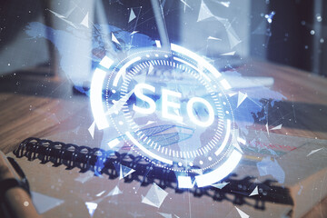 Multi exposure of SEO drawings and desk with open notebook background. Concept of Search...