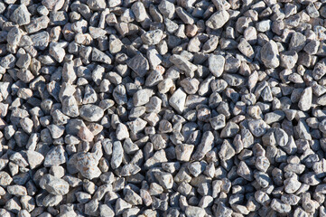 Small stones texture background; pile of light grey pebbles; decorative pathway