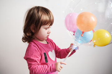 Fototapeta na wymiar Little girl holding a big Led Light Transparent Ballon With Handle.