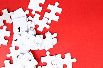 White puzzle pieces on red background, copy space for text.