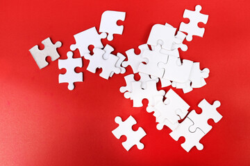White puzzle pieces on red background, copy space for text.
